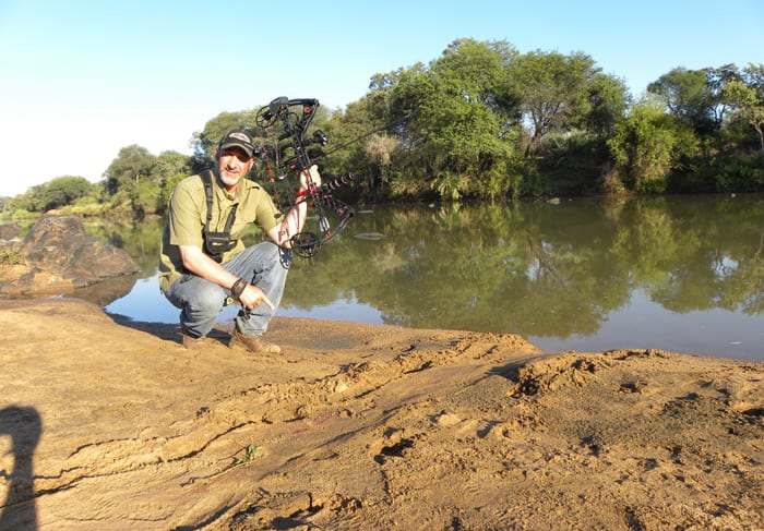 Author kneels in the sand, drag marks show the large croc was the one to take the bushbuck.